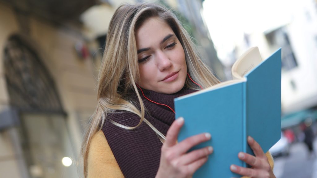 woman in purple scarf reading a book